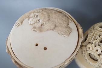 A late 19th century Chinese carved ivory concentric ball comprising seven reticulated spheres, with a small stand, and a Japanese carved ivory box (base missing), Meiji period, of cylindrical form, decorated with a black